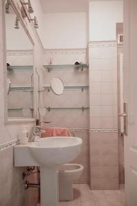 a white bathroom with a sink and a toilet at Lido Camaiore - Appartamento Il Pinolo in Camaiore