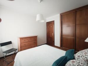 a bedroom with a bed and a chair at Apartamento Ribadesella playa in Ribadesella