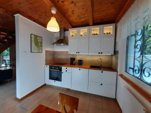 a kitchen with white cabinets and a sink at Dom nad Jeziorem Bory Tucholskie Pomost Łódka in Cierplewo +7 photos