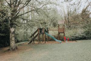 a playground with a slide in a park at La barra'k Maison de vacances avec piscine in Waimes