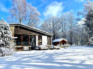 a log cabin with snow on the ground at La barra'k Maison de vacances avec piscine in Waimes