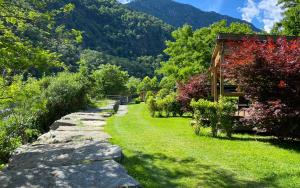 a garden with a stone path next to a house at Camping Piccolo Paradiso in Avegno