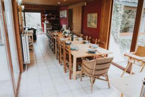 a dining room with a long table and chairs at La barra'k Maison de vacances avec piscine in Waimes