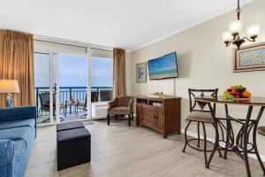 a living room with a couch and a table with a view of the ocean at WINTER RATES! Ready Set and Relax, Oceanfront Suite w Jetted tub! B 1134 in Myrtle Beach