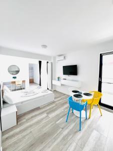 a living room with a bed and a table and chairs at Sea Panorama Apartments & Free Parking in Năvodari