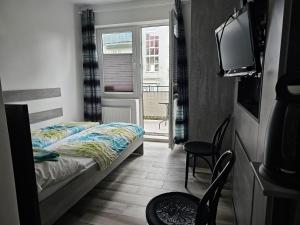 a small bedroom with a bed and a tv at Pokoje u Marii in Międzyzdroje
