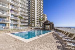 einem Pool vor einem großen Apartmenthaus in der Unterkunft Romar Place Condos in Orange Beach