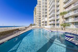 einem Pool vor einem großen Apartmenthaus in der Unterkunft Romar Place Condos in Orange Beach