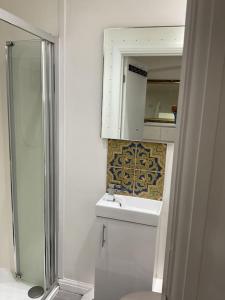 um banheiro com um vaso sanitário, uma pia e um espelho em Private apartment with en-suite em Bournemouth