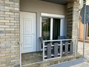 a porch with two chairs and a white door at Haus Viktoria 4 in Limenas