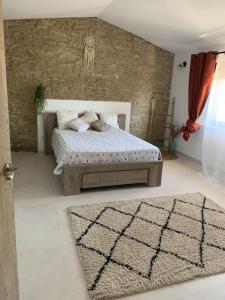 a bedroom with a bed and a rug at Maison de vacances toute équipée à 5mn du Pont-du-Gard au Cœur de Sernhac in Sernhac
