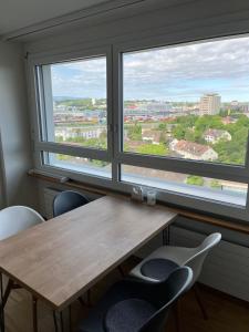 バーゼルにあるWohnung Basel City bis max 6 Personenの窓が2つある部屋にテーブルと椅子がある