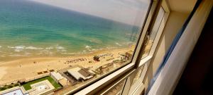 an ocean view of a beach from a window at 8 Hotel Apartment Short Time TLV BAT YAM in Bat Yam