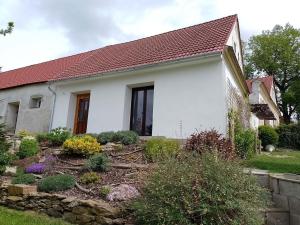a white house with a garden in front of it at Vejměnek Tuchonice in Žimutice