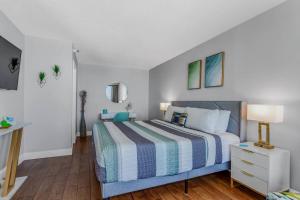 a bedroom with a bed with a blue and white comforter at Pristine Oceanfront King Suite Best Layout in Bldg 806 in Myrtle Beach +22 photos