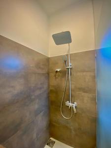 a bathroom with a shower with a shower head at Woodnest Villa Rustic in Kochchikade