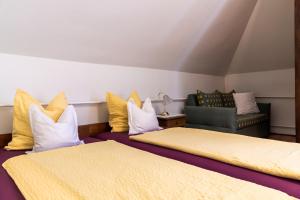 a room with two beds and a couch and a chair at Magdalena Apartmanház in Keszthely