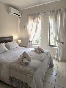 a bedroom with a large bed with towels on it at 9 The Bridge Holiday Resort in St Lucia +30 photos