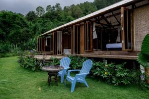 two chairs and a table in front of a house at Calidas Hill in Kintamani