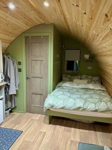 a bedroom with a bed with a wooden ceiling at Knockmany View Glamping in Augher