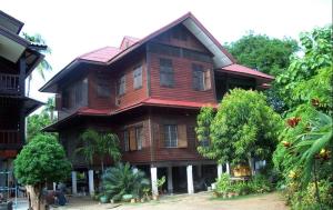 a large wooden house with trees in front of it at Baan Lotus Guest House in Phra Nakhon Si Ayutthaya