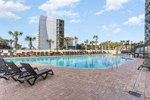 マートルビーチにあるWINTER RATES! Make Memories Ravishing Angled Oceanfront Suite OR 916の椅子と建物のある大きなプール