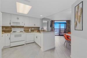 マートルビーチにあるWINTER RATES! Make Memories Ravishing Angled Oceanfront Suite OR 916のキッチン(白い家電製品、眺めの良いテーブル付)