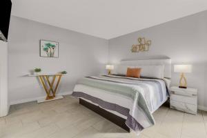 マートルビーチにあるWINTER RATES! Make Memories Ravishing Angled Oceanfront Suite OR 916の白いベッドルーム(ベッド1台、テーブル付) +27枚の写真