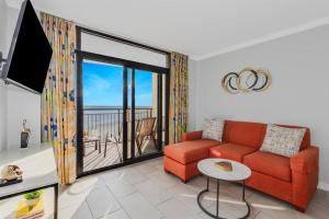 マートルビーチにあるWINTER RATES! Make Memories Ravishing Angled Oceanfront Suite OR 916のリビングルーム(赤いソファ、バルコニー付)