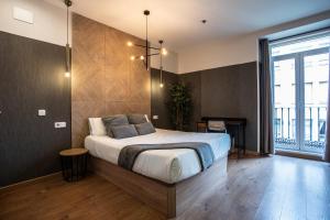 sypialnia z łóżkiem i dużym oknem w obiekcie Suites You Zinc w Madrycie