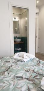 a bedroom with a bed and a bathroom with a mirror at B&B DieMme Amalfi Coast in Vietri sul Mare