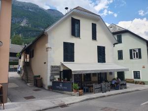 a large white building with people sitting outside of it at Apartma Mirko in Bovec