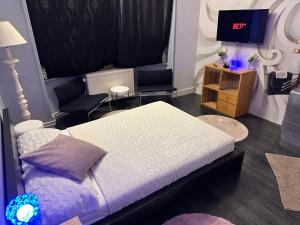 a bedroom with a bed and a tv in it at Chambre Neptune in Brussels
