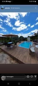 TV con schermo e foto di una piscina di Chácara Canaã a Valença