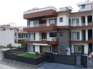 苏哈纳Ginger Garlic Chandigarh的一栋前面有草坪的公寓楼