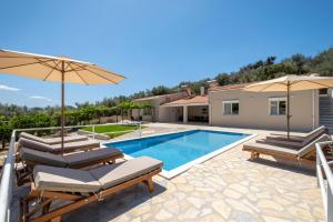 a villa with a swimming pool and umbrellas at Tolo Villa Natura with Pool for 8 - private, luxury accommodation in Tolo