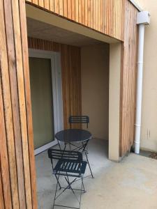 a patio with a table and chairs in a building at Le Lodge in Angoulême