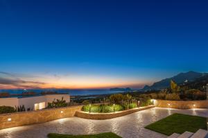 a villa with a view at night at Diamond Star Hotel in Falasarna