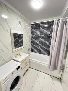a bathroom with a sink and a washing machine at Просторная квартира 3 х ком в Новом районе in Shymkent