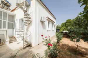 a white house with a spiral staircase on the side of it at Bright & Cozy House near Beach in Athens
