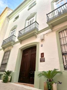 a building with a wooden door and two balconies at Garden Suites Xativa Casa Rural in Xàtiva