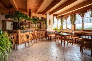 a restaurant with wooden tables and chairs and windows at Weingut Juritsch in Leutschach