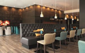 a restaurant with a table and chairs and a fireplace at Motel One Manchester-Piccadilly in Manchester