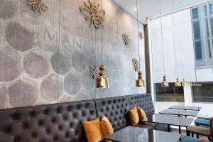 a restaurant with a leather bench and tables and lights at Motel One Manchester-Piccadilly in Manchester