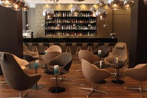 a row of chairs and tables in a room with a bar at Motel One Manchester-Piccadilly in Manchester