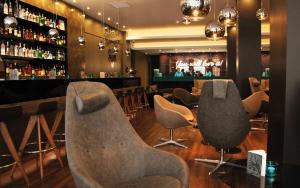 a bar with a row of chairs in a room at Motel One Manchester-Piccadilly in Manchester