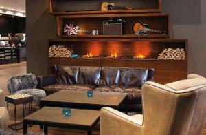 a living room with a leather couch and a fireplace at Motel One Manchester-Piccadilly in Manchester