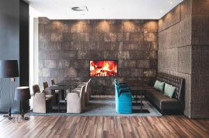 a restaurant with a fireplace and leather chairs and tables at Motel One Manchester-Piccadilly in Manchester