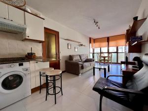 a kitchen and living room with a washing machine at Apartamento Loredo in Loredo