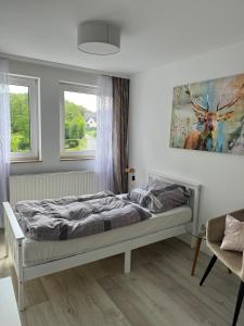 a bedroom with a bed in a room with two windows at Hotel Zur Mühle in Iserlohn